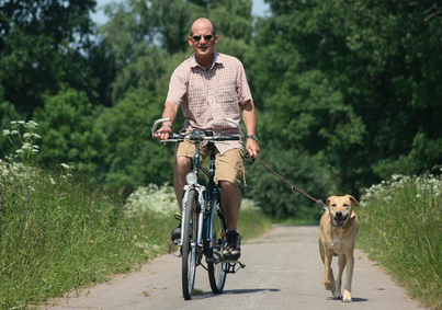Herrchen fährt mit dem Hund Fahrrad